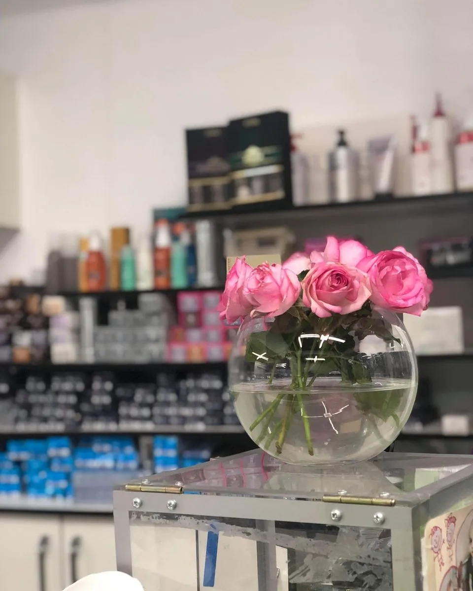 Raft cu produse la Beauty Life Salon, cu un buchet de trandafiri roz